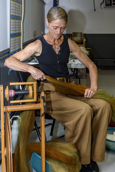 Christina elongates the prepared roving before spinning.