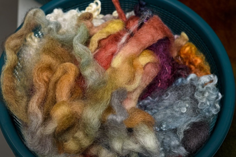 Basket of colored roving, red, white, peach, yellow, blue.