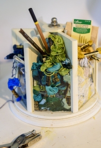 Embroidery floss, paintbrushes and pens.