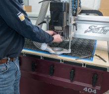Setting up the cutting machine to cut and shape the bobbin ends. Setting up the cutting machine to cut and shape the bobbin ends.