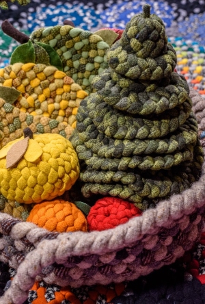 Braided apples, pears, and evergreens in a basket.