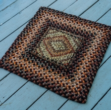A hooked rug with braided edges. Fascinating colors.