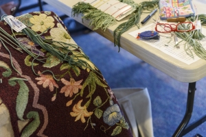 Janis Ricker works on a rug at the meeting.