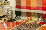Small buttons, printed photos, and a weaving sampler installed in the studio.