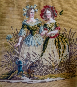 A needlepoint tapestry depicting ladies of the times.