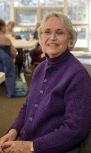 Page Hammond has designed and handknit this purple sweater.